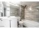 Modern bathroom with a tub and shower combination with gray tiled walls and a white vanity with a large mirror at 6240 N 16Th St # 40, Phoenix, AZ 85016