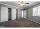 Spacious bedroom features a ceiling fan, neutral walls and carpet, and double closets with shelving at 6240 N 16Th St # 40, Phoenix, AZ 85016