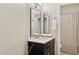 Bathroom with a dark vanity, white countertop, dual mirrors, and a shower/tub combo at 6828 E Evans Dr, Scottsdale, AZ 85254