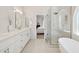 Luxurious bathroom showcases a freestanding tub, glass shower and elegant white vanity with dual sinks at 6828 E Evans Dr, Scottsdale, AZ 85254