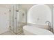 Luxurious primary bathroom featuring a freestanding tub, and a glass-enclosed shower with a built-in bench at 6828 E Evans Dr, Scottsdale, AZ 85254
