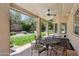 Inviting covered patio featuring a round dining table and views of the manicured backyard at 6828 E Evans Dr, Scottsdale, AZ 85254