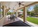 Relaxing covered patio with ceiling fans, dining set, and view of the beautifully landscaped yard and pool at 6828 E Evans Dr, Scottsdale, AZ 85254