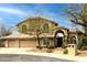 Tan two-story stucco home featuring desert landscaping, a tiled roof, and a three car garage at 6828 E Evans Dr, Scottsdale, AZ 85254
