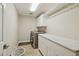Well-organized laundry room with modern washer, dryer, cabinets, and marble countertop at 6828 E Evans Dr, Scottsdale, AZ 85254