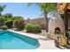 Backyard featuring a pool, outdoor fireplace, mature landscaping, and a view of the outdoor living area at 6828 E Evans Dr, Scottsdale, AZ 85254