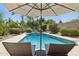 Serene pool area with lounge chairs, lush greenery, and a soothing water feature in the backyard at 6828 E Evans Dr, Scottsdale, AZ 85254