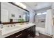 Bright bathroom with dual sinks, quartz countertop, large mirror, and tiled shower at 7053 S Heather Dr, Tempe, AZ 85283