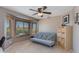Bright bedroom with bay window, ceiling fan, futon, and shelving unit at 7053 S Heather Dr, Tempe, AZ 85283