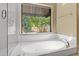 Bright soaking tub in bathroom with garden view through large window at 7168 N Via De Amigos --, Scottsdale, AZ 85258