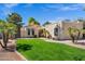 Charming single-story home with a lush green lawn, mature trees, and appealing desert landscaping at 7168 N Via De Amigos --, Scottsdale, AZ 85258