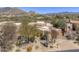An aerial view of a tan home and desert landscaping in an upscale community with mountain views at 7322 E High Point Dr, Scottsdale, AZ 85266