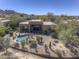 Aerial view of a luxurious home with a pool and lush desert landscaping at 7322 E High Point Dr, Scottsdale, AZ 85266