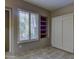 Bedroom featuring a window with shutters, built-in shelves, and carpet floors at 7322 E High Point Dr, Scottsdale, AZ 85266