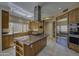 Spacious kitchen with wood cabinets, granite countertops, stainless steel appliances, and a center island cooktop at 7322 E High Point Dr, Scottsdale, AZ 85266