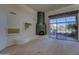 Bright living room featuring a unique fireplace, decorative display, and patio access with great views at 7322 E High Point Dr, Scottsdale, AZ 85266