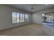 Bright living room featuring a ceiling fan, a large window, and sliding glass door leading to the patio at 7322 E High Point Dr, Scottsdale, AZ 85266