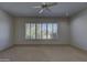 Bright living room featuring a ceiling fan and a large window with mountain views at 7322 E High Point Dr, Scottsdale, AZ 85266