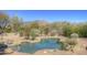 Scenic pool area featuring a freeform pool, desert landscaping, and mountain views at 7322 E High Point Dr, Scottsdale, AZ 85266