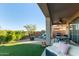 Backyard with artificial turf, covered patio with fan, and lounge seating at 8205 S Pioneer Ct, Gold Canyon, AZ 85118