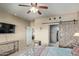 Bedroom with ceiling fan, TV, and wooden sliding barn door leading to bathroom and closet at 8205 S Pioneer Ct, Gold Canyon, AZ 85118