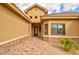 Covered entry features stone accents and a black metal door, with brick paver flooring and desert landscaping at 8474 W Switchback Trl, Casa Grande, AZ 85194