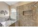 Bright bathroom features a soaking tub and glass enclosed shower with decorative tile and window views at 9706 E Sheena Dr, Scottsdale, AZ 85260