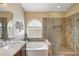 Elegant bathroom features a soaking tub, glass-enclosed shower, and stylish vanity at 9706 E Sheena Dr, Scottsdale, AZ 85260