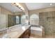Bathroom featuring dual sinks, soaking tub, and glass enclosed shower with decorative tile at 9706 E Sheena Dr, Scottsdale, AZ 85260