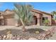 Attractive home featuring desert landscaping with rocks, cacti, and mature palm trees at 9706 E Sheena Dr, Scottsdale, AZ 85260