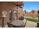 Covered patio with ceiling fan, outdoor dining set, and access to backyard at 9706 E Sheena Dr, Scottsdale, AZ 85260
