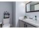 Compact half bathroom featuring a gray vanity with white countertop and a standard toilet at 10865 E Florian Ave, Mesa, AZ 85208