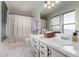 Bright bathroom featuring double sinks, a large mirror, and a shower-tub combo with white shower curtain at 10865 E Florian Ave, Mesa, AZ 85208