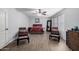 Primary bedroom features wood-look flooring, neutral walls, ceiling fan, and a cozy seating area at 10865 E Florian Ave, Mesa, AZ 85208