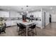 Bright kitchen features white cabinets, stainless steel appliances, a center island, and wood-look tile flooring at 10865 E Florian Ave, Mesa, AZ 85208