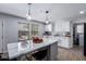 Modern kitchen features white cabinets, stainless steel appliances, a large center island, and views of the backyard at 10865 E Florian Ave, Mesa, AZ 85208