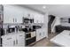 Bright kitchen features white cabinets, stainless steel appliances and eat-in countertop with views of stairs at 10865 E Florian Ave, Mesa, AZ 85208