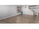 Empty living space with wood-look tile flooring, a window with blinds, a modern chandelier, and stairs at 10865 E Florian Ave, Mesa, AZ 85208