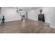 Open living area with neutral walls, wood-look tile flooring, stairs leading upstairs, and a modern light fixture at 10865 E Florian Ave, Mesa, AZ 85208