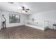Upstairs loft featuring wood-look flooring, a ceiling fan, and a large window for natural light at 10865 E Florian Ave, Mesa, AZ 85208