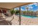 Enjoy a tranquil pool view with a hammock and a covered patio at 10865 E Florian Ave, Mesa, AZ 85208