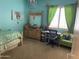 Bright turquoise bedroom with a full bed, whimsical décor, and natural light from a window at 10980 E Winchcomb Dr, Scottsdale, AZ 85255