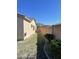 Side of the house shows a narrow strip of grass and a low block wall for privacy at 10980 E Winchcomb Dr, Scottsdale, AZ 85255