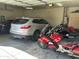 Spacious garage with multiple vehicles including cars and motorcycles at 10980 E Winchcomb Dr, Scottsdale, AZ 85255