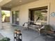 Inviting covered patio with wicker chairs, side table, and garden planters for comfortable outdoor living at 10980 E Winchcomb Dr, Scottsdale, AZ 85255