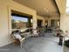 Spacious covered patio furnished with wicker seating, dining set, and potted plants for outdoor entertaining at 10980 E Winchcomb Dr, Scottsdale, AZ 85255