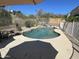 Backyard pool area with concrete patio, desert landscaping, a basketball hoop, and seating at 10980 E Winchcomb Dr, Scottsdale, AZ 85255