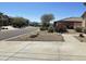Charming home with desert landscaping, mature trees, and an American flag on display at 10980 E Winchcomb Dr, Scottsdale, AZ 85255