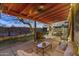 A cozy outdoor living area with cushioned seating, lighting, and views of lush landscaping at 1422 E Royal Palm Rd, Phoenix, AZ 85020