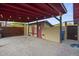 Cozy backyard carport featuring string lights, red accents, rock flooring, and convenient storage spaces at 1422 E Royal Palm Rd, Phoenix, AZ 85020